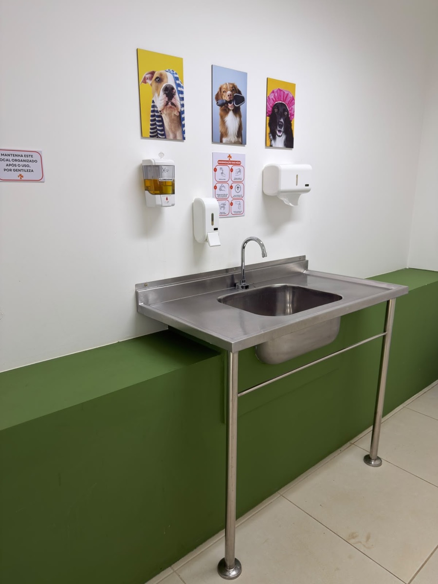 Lavabo de paramentação da COEV, com cuba inox, clorexidina, álcool e o passo a passo de higienização das mãos na parede