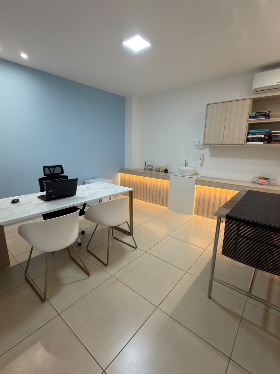 Consultório da COEV com mesa de atendimento, bancada iluminada e maca inox